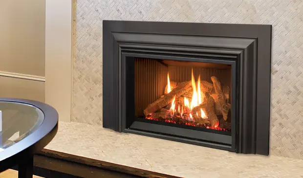 Look classique avec l'insert au gaz Enviro EX32 et sa façade décorative traditionnelle, mis en valeur par un contour en mosaïque pâle.