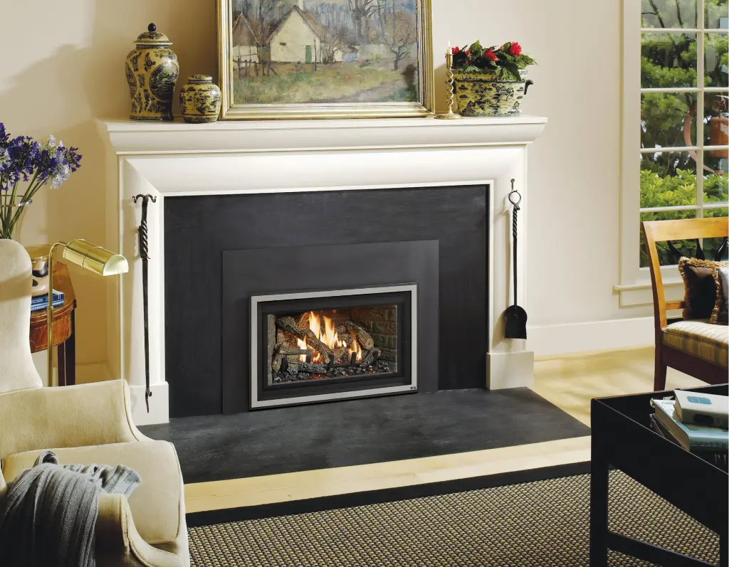 Look sobre et élégant avec l'insert au gaz 32 DVS et une façade en acier inoxydable, sur un large contour en ardoise noire.