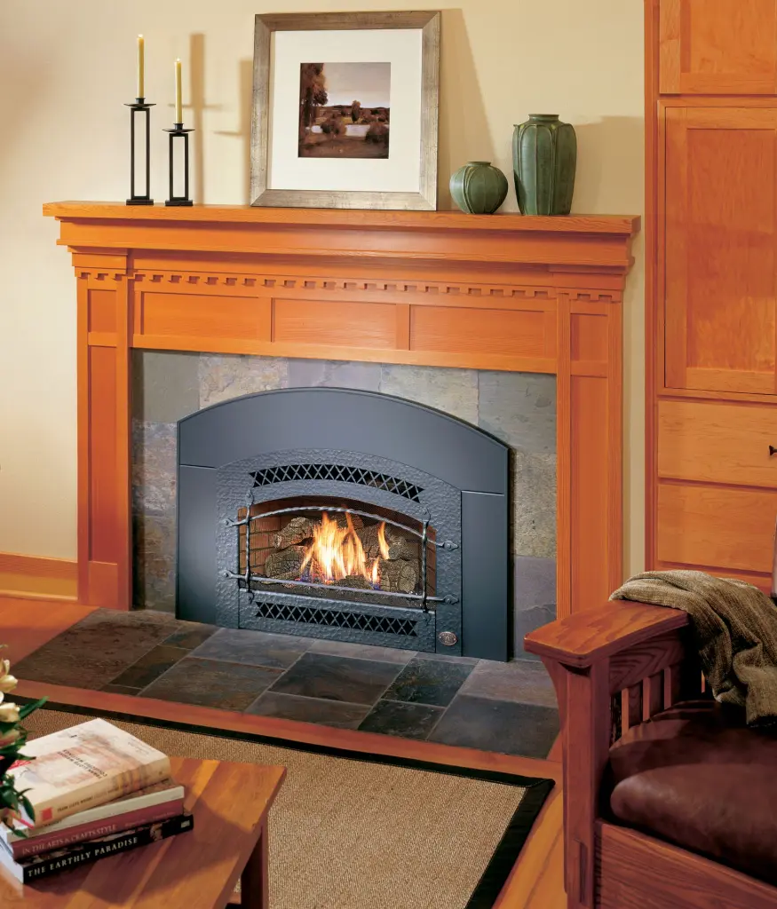 Insert au gaz 32 DVS de Fireplace Xtrordinair avec une façade arquée de style forge, dans un manteau en bois de style Craftsman et un contour en ardoise.