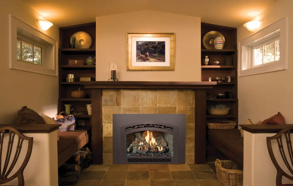 Coin détente "cozy" avec l'insert au gaz 32 DVS et sa façade arquée, installé dans un foyer en tuiles de pierre avec des banquettes intégrées.