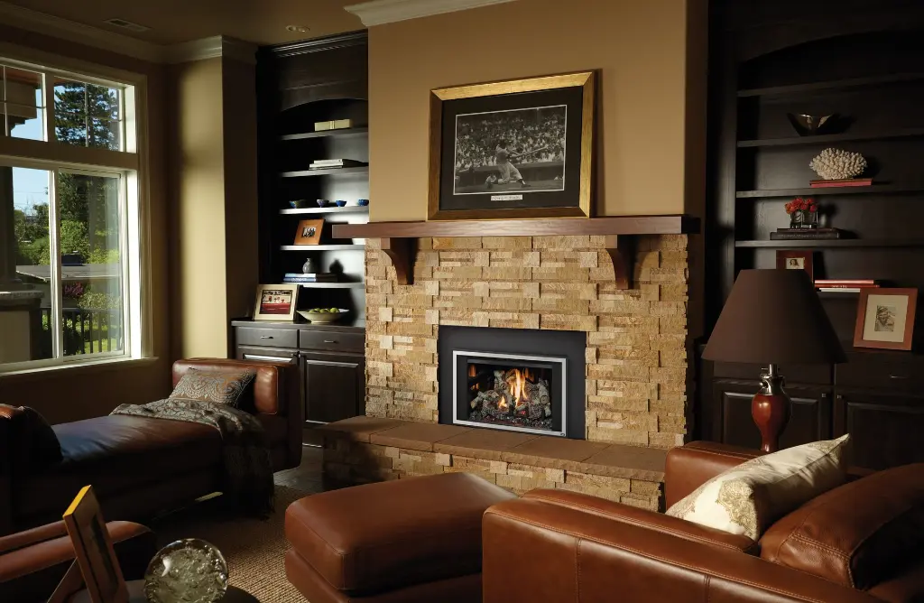 Coin détente masculin et confortable avec le foyer au gaz 430 Deluxe, encastré dans un mur de pierres décoratives et entouré de bibliothèques foncées.