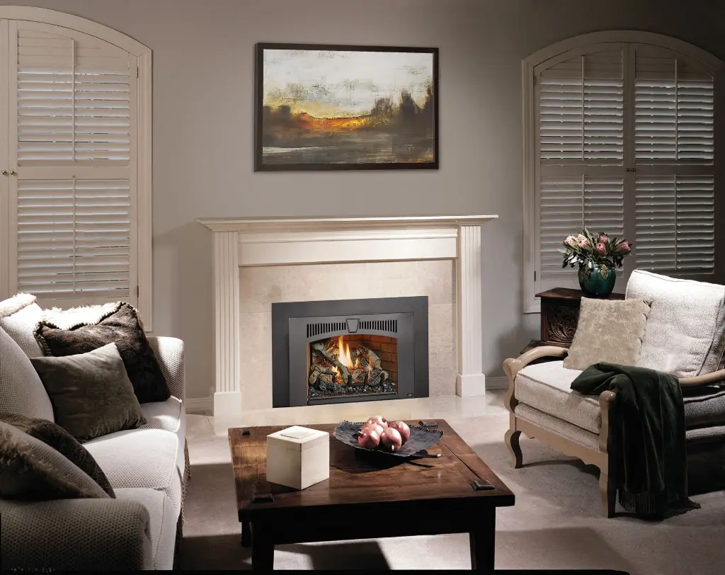 Élégance classique avec le foyer au gaz 430 Deluxe et sa façade arquée, intégré dans un manteau de foyer blanc traditionnel sur un fond de tuiles pâles.