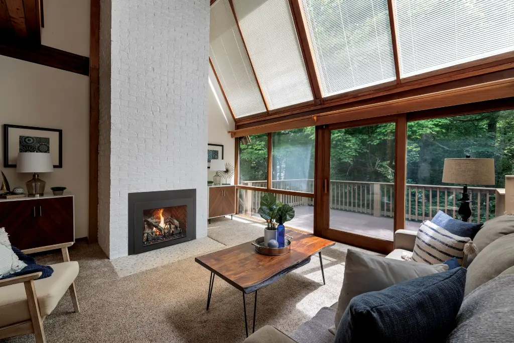 Style Mid-Century Modern avec le foyer au gaz 616 Deluxe, installé dans une cheminée en briques peintes en blanc avec un plafond cathédrale.