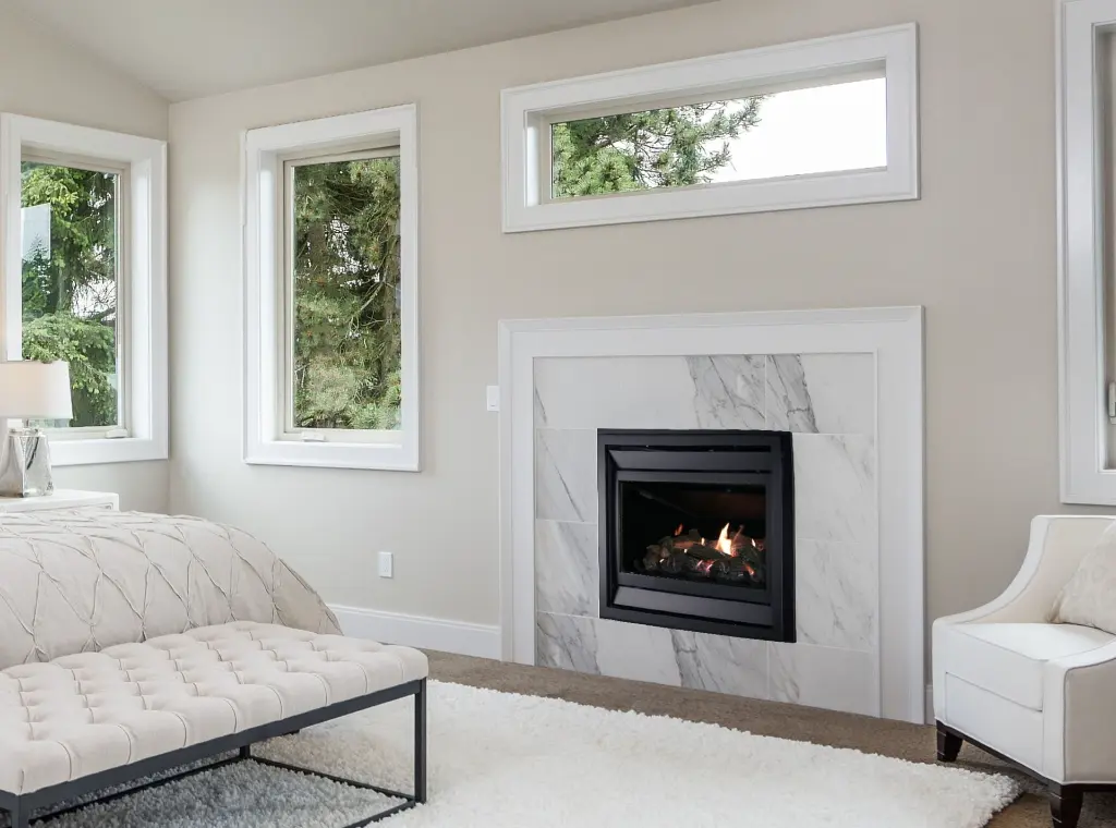 Foyer au propane traditionnel Éclipse installé avec une finition en marbre dans une chambre à coucher.