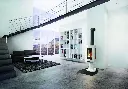 Idée de design pour un loft au style industriel, mettant en valeur le poêle au gaz Jotul GF 370 blanc comme point focal devant une bibliothèque intégrée.