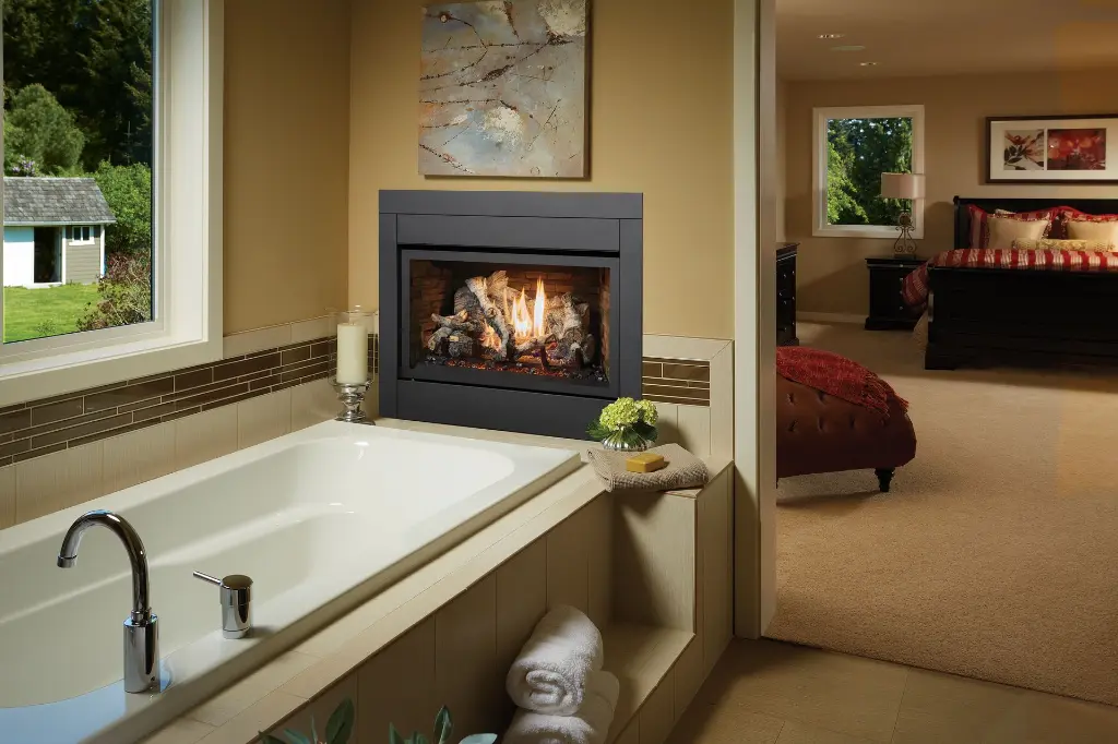 Ambiance de spa luxueuse avec un foyer au gaz 564 TRV 25K CF installé dans le contour d'un bain, reliant la salle de bain à la chambre des maîtres.