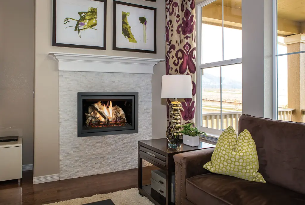 Foyer au gaz 564 TRV 25K CF créant un point focal élégant dans un mur de pierres blanches empilées avec un manteau de foyer classique.