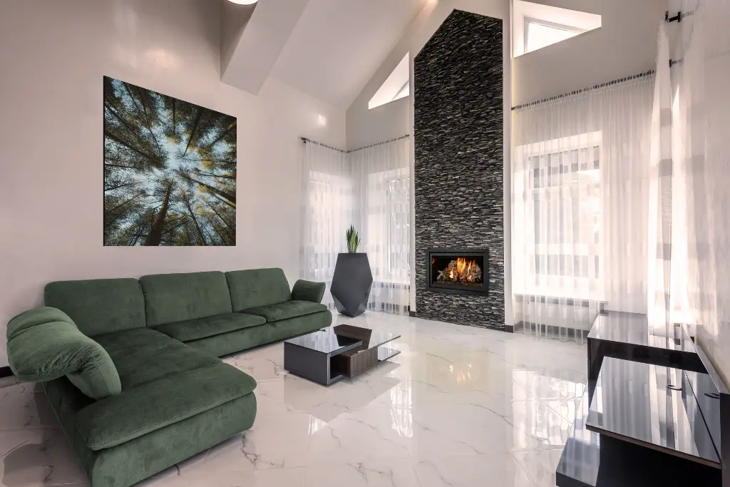 Design spectaculaire avec un foyer au gaz 564 TV 35K installé dans une cheminée pleine hauteur en pierres noires empilées, dans un salon de luxe avec plancher de marbre.