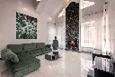 Design spectaculaire avec un foyer au gaz 564 TV 35K installé dans une cheminée pleine hauteur en pierres noires empilées, dans un salon de luxe avec plancher de marbre.