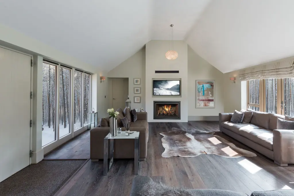 Vaste salon avec plafond cathédrale, centré autour d'un foyer au gaz 564 TV 35K pour une ambiance chaleureuse et invitante.
