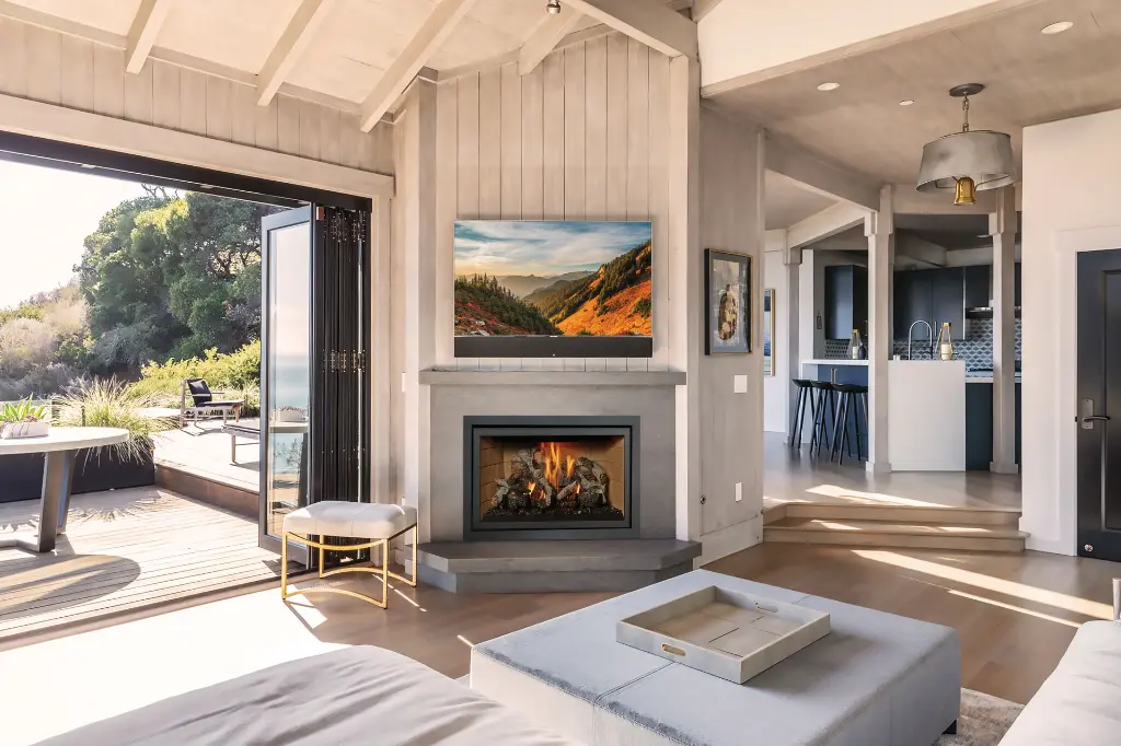 Style de bord de mer décontracté avec le foyer au gaz 564 TV 35K, installé sous une télévision dans un manteau de foyer en béton épuré.