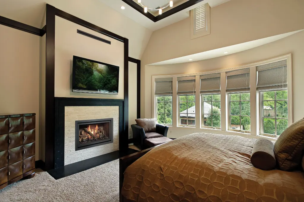 Foyer au gaz 564 TV 35K créant une ambiance de luxe et de confort dans une chambre des maîtres avec un coin lecture près de la fenêtre.