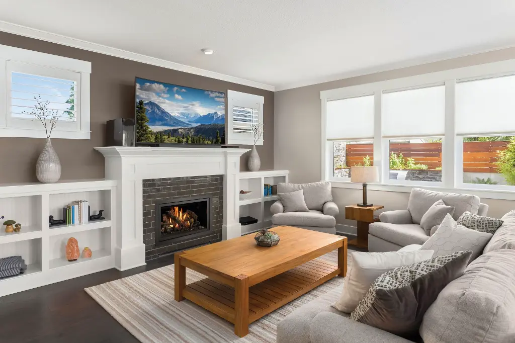 Intégration du foyer au gaz 564 TV 35K dans un meuble multimédia blanc sur mesure avec un contour en tuiles de céramique foncées.