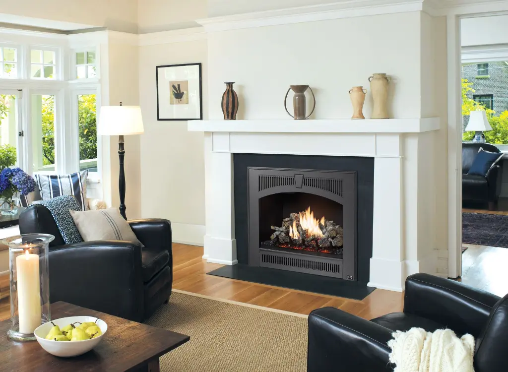 Style transitionnel épuré avec le foyer au gaz 864 TRV 31K, doté d'une façade arquée noire sur un contour en ardoise et un manteau blanc simple.