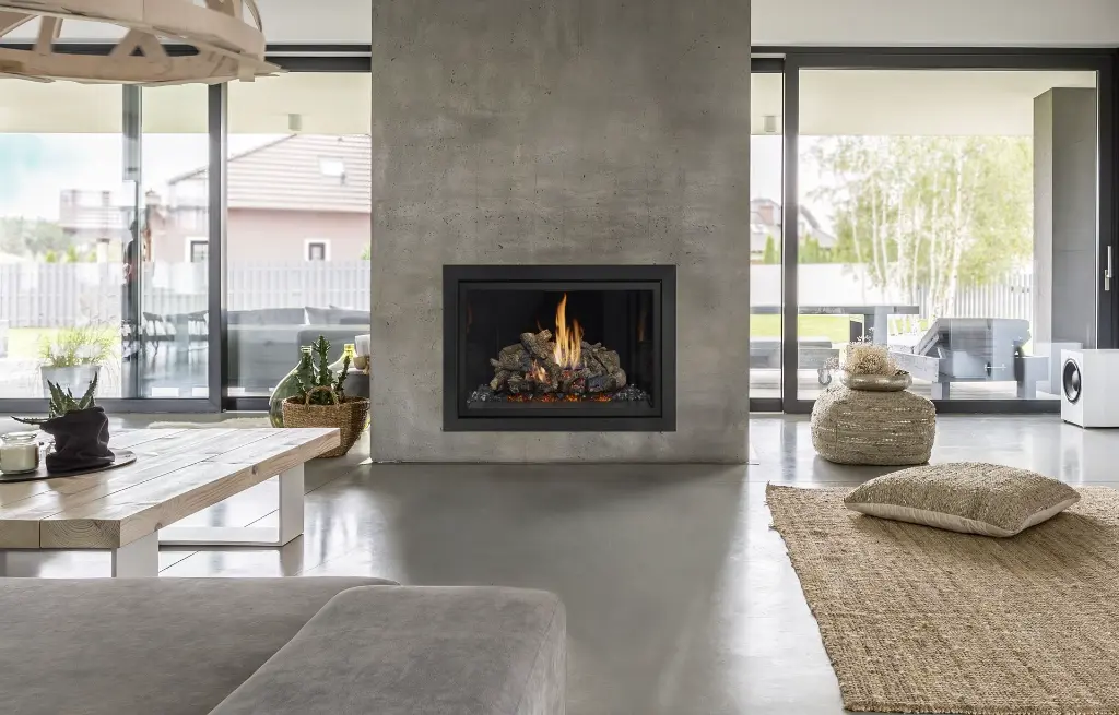 Design contemporain intérieur-extérieur avec un foyer au gaz 864 TV 40K "Clean Face" intégré dans un mur de foyer en béton épuré.