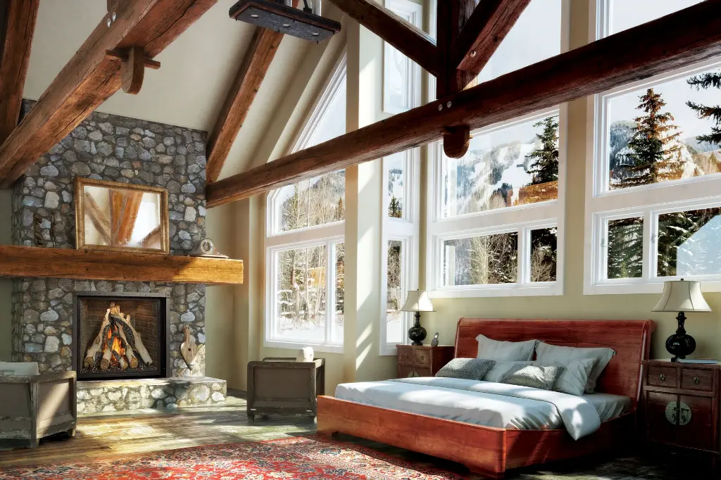 Suite des maîtres spectaculaire de style chalet avec le foyer au gaz 4237 Ember-Glo, poutres de bois apparentes et vue sur les montagnes enneigées.