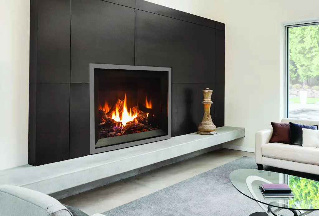 Design minimaliste et audacieux avec le foyer au gaz Enviro G39, installé sur un long banc en béton devant un mur de panneaux noirs mats.