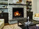 Foyer au gaz Enviro G42 encastré dans un mur de pierres décoratives pâles, créant un point focal entre deux bibliothèques sur mesure.