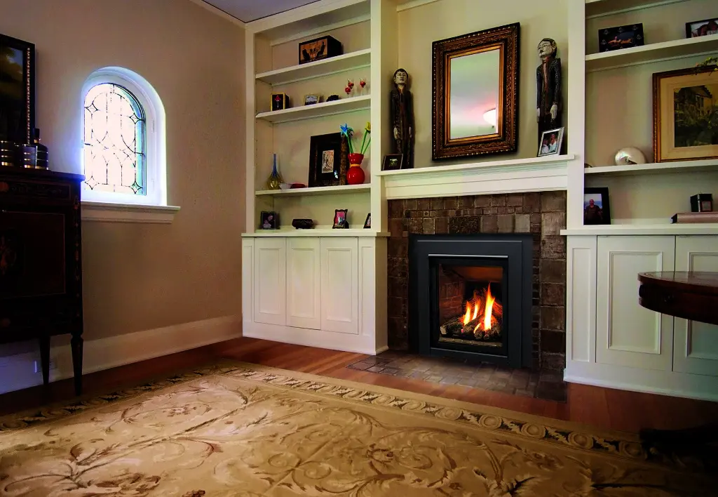 Ambiance traditionnelle avec le foyer au gaz Enviro Q1, intégré dans un contour de tuiles de céramique et flanqué de bibliothèques blanches sur mesure.
