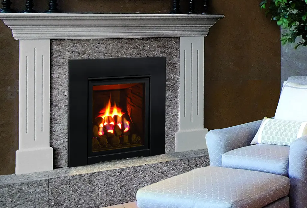 Style néoclassique avec le foyer au gaz Enviro Q1, installé dans un manteau de foyer à colonnes sur un fond de pierres décoratives.