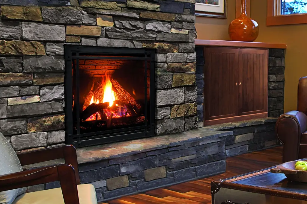 Grand foyer au gaz vertical Enviro Q3, créant une ambiance de chalet rustique dans une cheminée en pierres empilées avec un âtre surélevé.