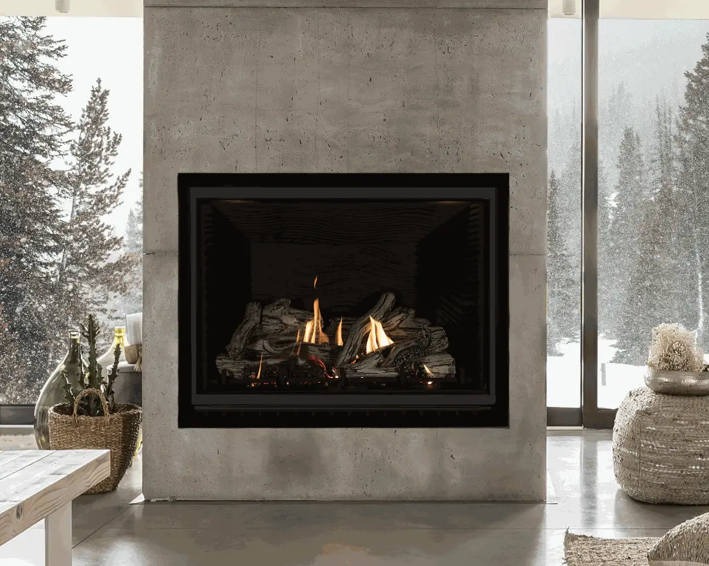 Design minimaliste et architectural avec le grand foyer au gaz Sereno 41 d'Archgard, encastré dans un mur de béton brut avec vue sur un paysage d'hiver.