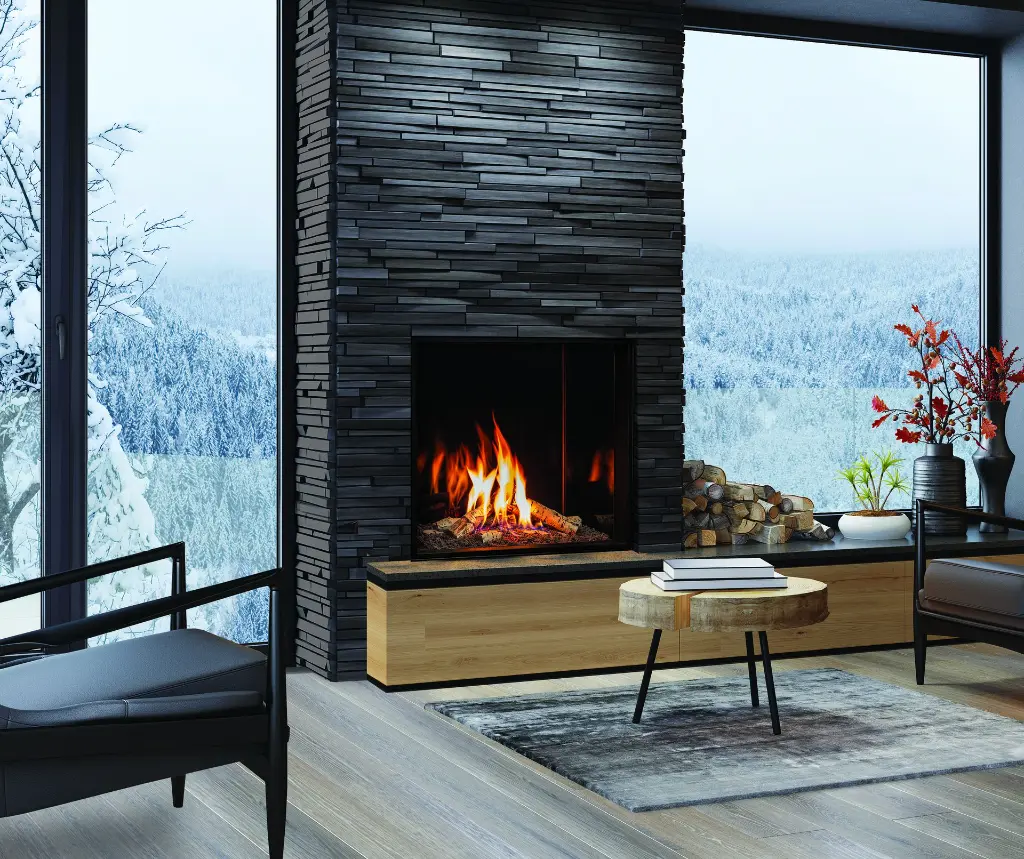 Foyer au gaz carré Urbana U33, créant un point focal spectaculaire dans un mur de pierres noires empilées avec une vue sur un paysage d'hiver.