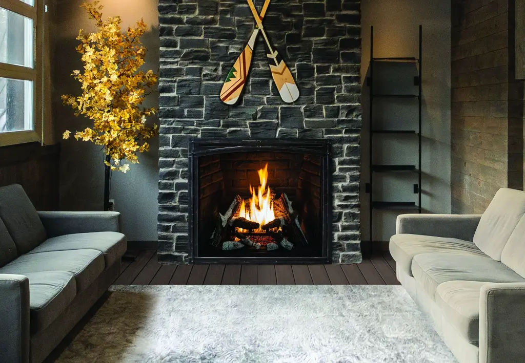 Ambiance de chalet rustique avec le foyer au gaz Urbana U37, installé dans une cheminée en pierres de rivière noires et décoré de rames.