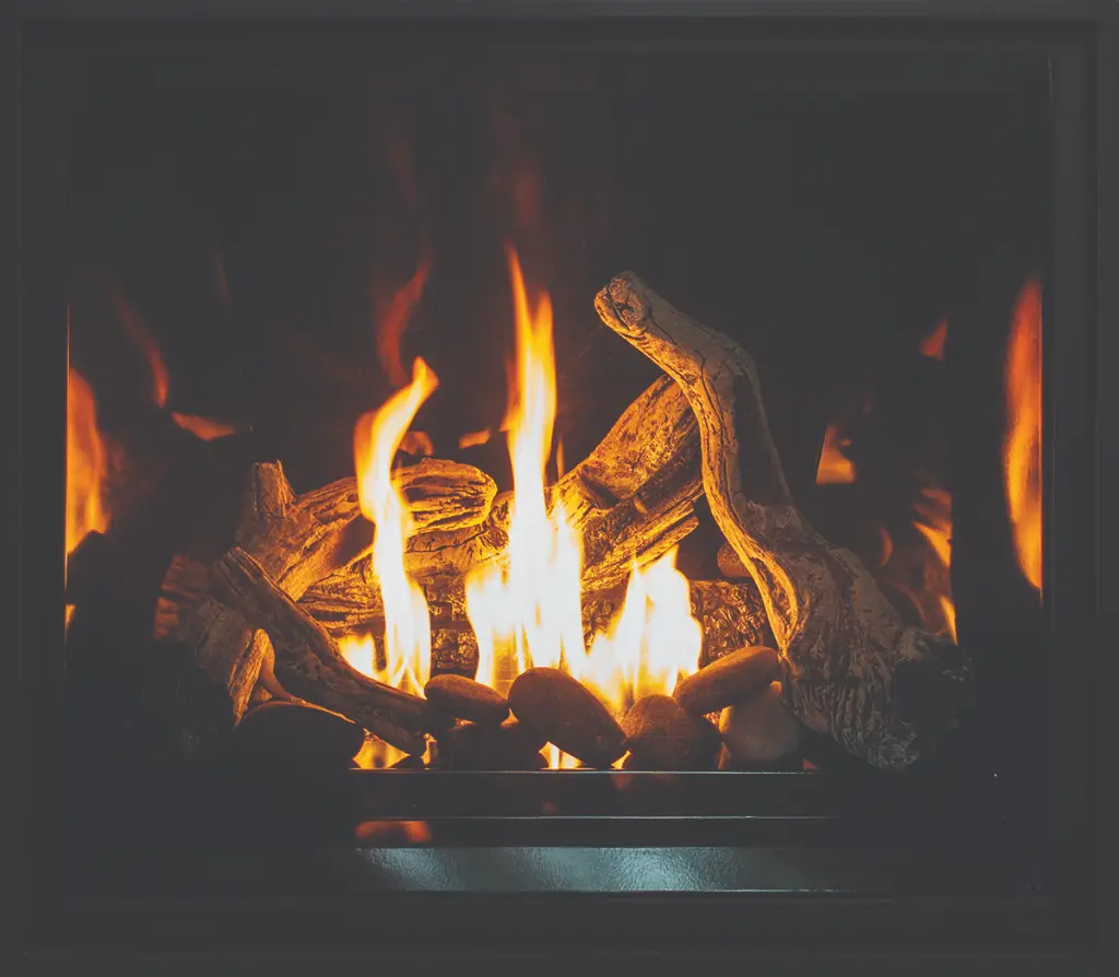 Option de bûches de bois de grève (driftwood) et de pierres pour le foyer Urbana U37, sur un fond réfléchissant pour un style côtier.