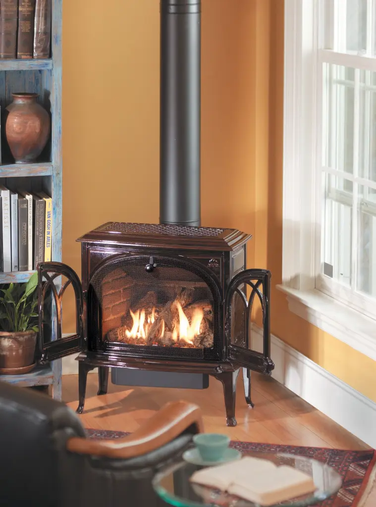 Poêle à gaz Jotul GF 400 brun émaillé avec ses portes grillagées ouvertes, créant un coin chaleureux de style champêtre à côté d'une bibliothèque.