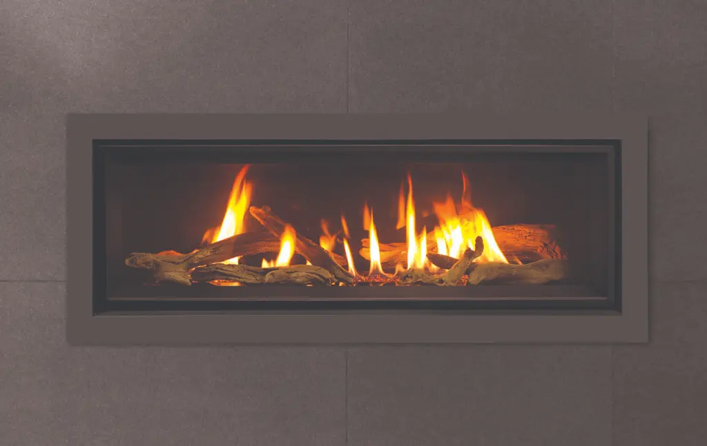 Foyer au gaz linéaire Enviro C44 avec un contour gris, créant un contraste subtil sur un mur de tuiles de porcelaine foncées.