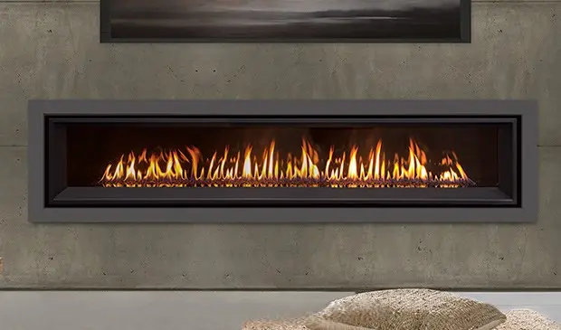 Gros plan sur le brûleur à ruban et la flamme panoramique du foyer au gaz linéaire Enviro C72, une pièce maîtresse du design moderne.