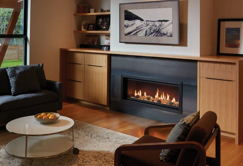 Foyer au gaz linéaire 4415 HO intégré dans un manteau en acier foncé, créant un contraste moderne avec des meubles en bois clair de style scandinave.