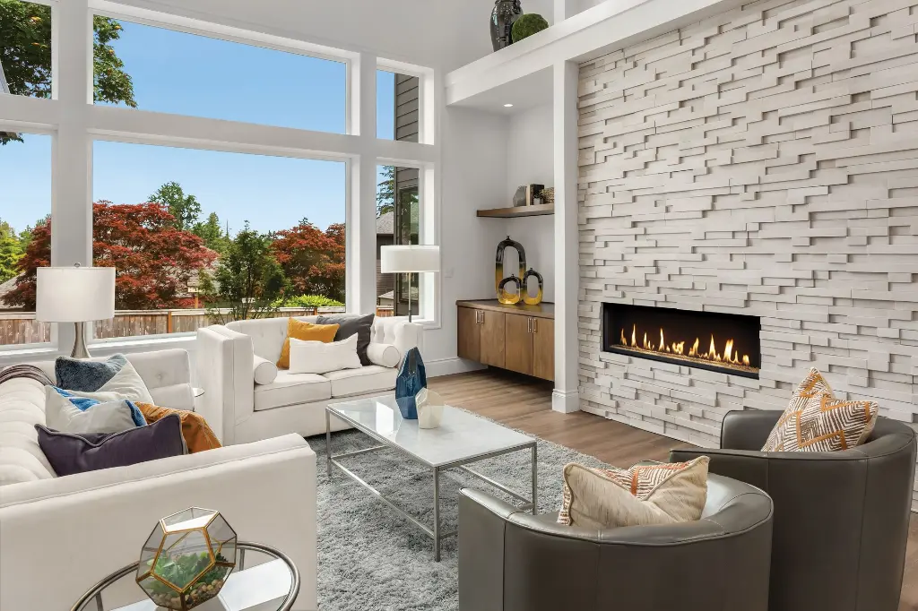 Design contemporain spectaculaire avec le foyer au gaz linéaire 4415 HO, encastré dans un mur d'accent en pierres blanches texturées 3D.