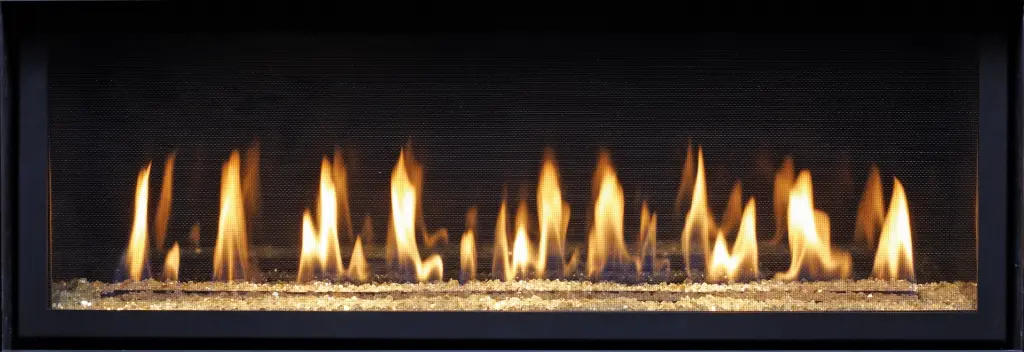 Vue rapprochée des flammes dansant sur un lit de billes de verre, une option moderne pour le foyer au gaz linéaire 4415 HO.