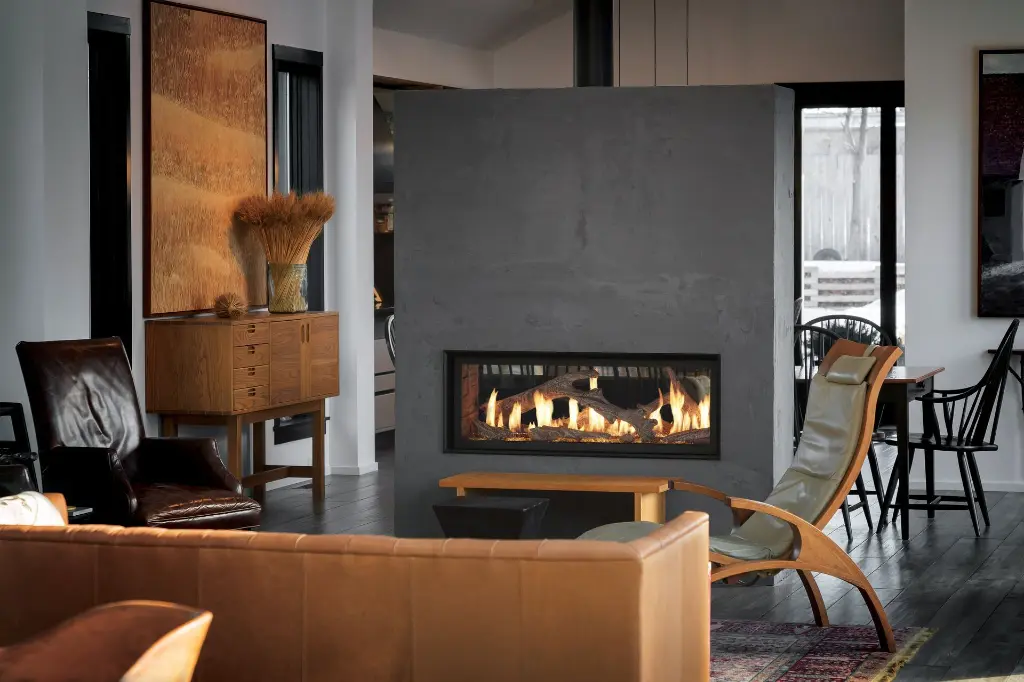 Foyer au gaz double face 4415 HO See-Thru, utilisé comme un séparateur de pièce architectural dans un mur structural en béton pour un design à aire ouverte.