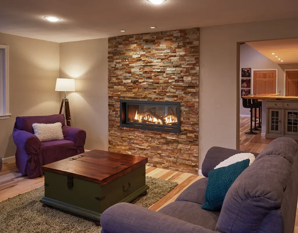 Foyer au gaz double face 4415 HO See-Thru, créant un point focal chaleureux dans un mur d'accent en pierres décoratives modernes.