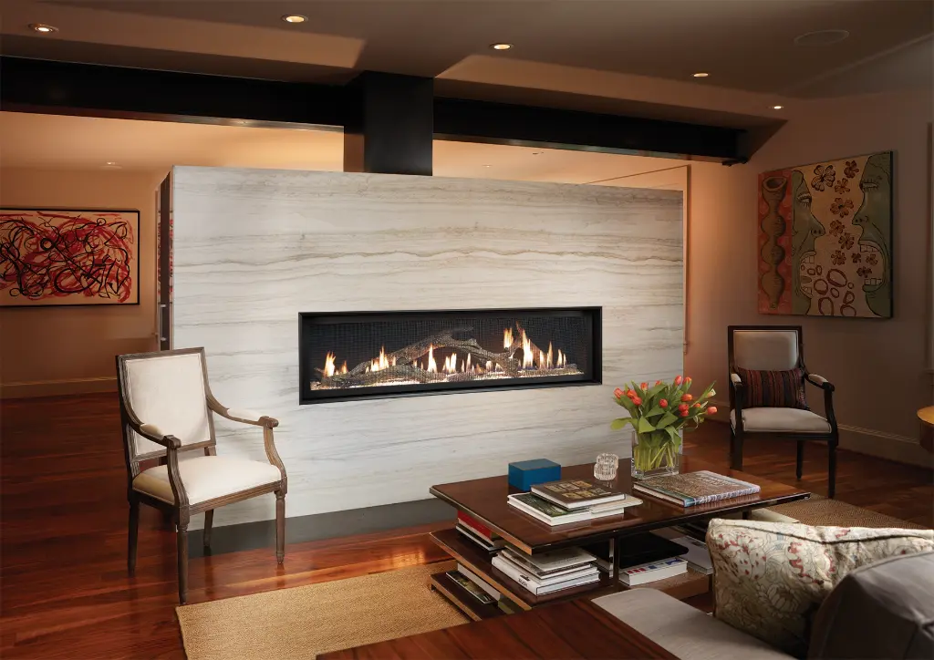 Foyer au gaz linéaire 6015 HO encastré dans un mur de marbre pleine hauteur, servant de séparateur de pièce élégant.