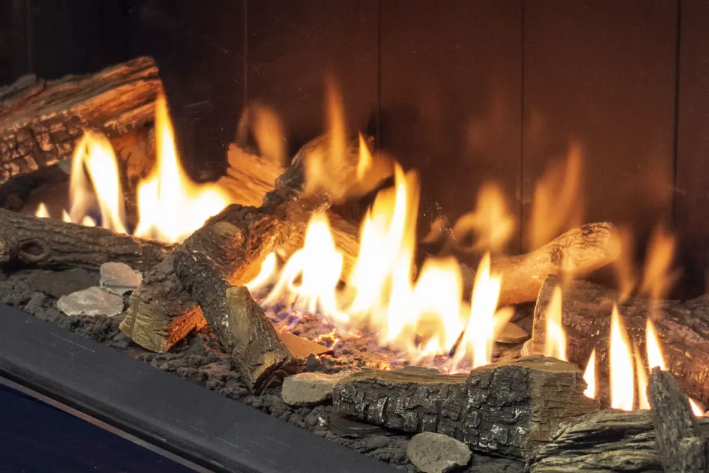 Vue en angle montrant la profondeur et le réalisme du jeu de bûches du foyer au gaz Urbana U70 Tall.