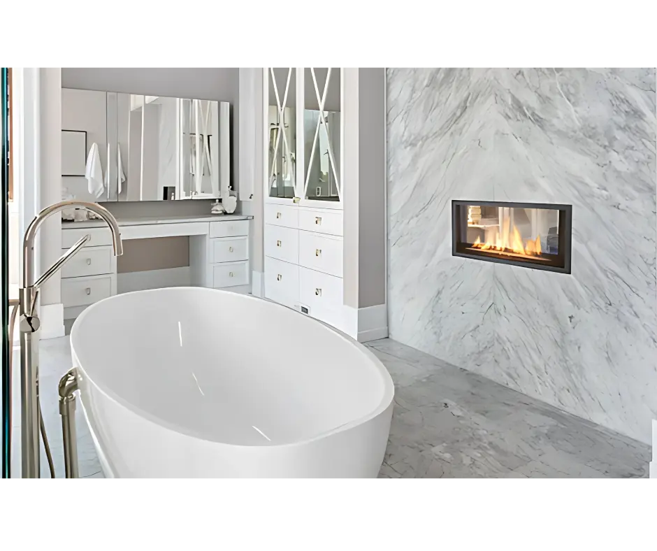 Foyer au gaz linéaire double face Canyon 35, créant une ambiance de spa de luxe dans une salle de bain avec un mur en marbre et un bain autoportant.