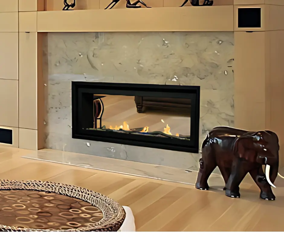 Foyer au gaz linéaire double face Bonaparte 48, créant une séparation luxueuse entre deux pièces avec une finition en marbre et boiseries claires.