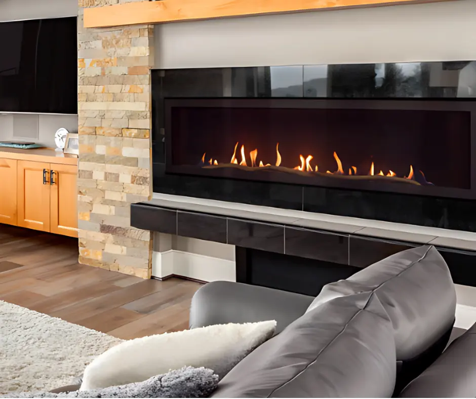 Grand foyer au gaz linéaire Summit 65 de Savannah, créant un look contemporain avec un contour en granite noir et un mur de pierres décoratives pâles.