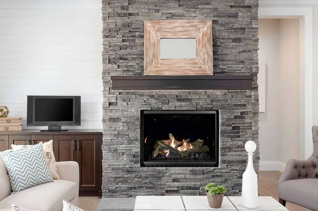 Foyer au gaz Sereno 37 d'Archgard au cœur d'un mur d'accent en pierres décoratives grises, complétant un décor de style "Modern Farmhouse" avec un mur adjacent en "shiplap" blanc.