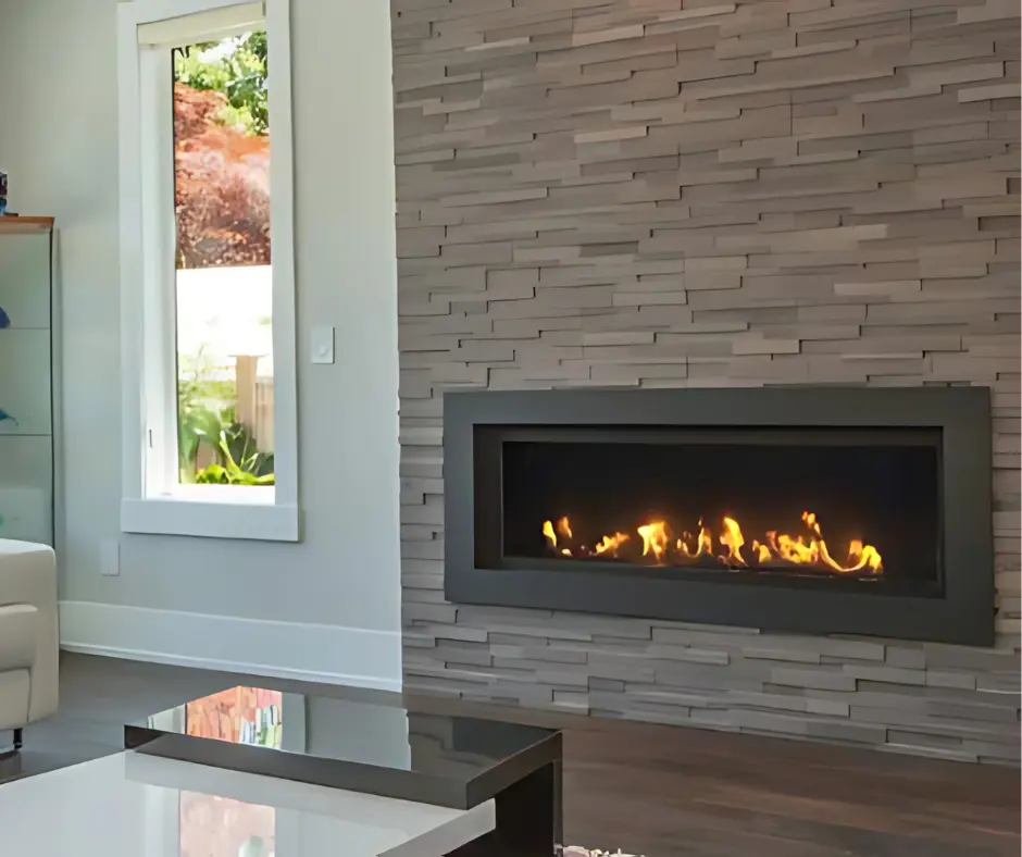 Foyer au gaz linéaire Pinnacle 55 de Savannah, créant un look contemporain et texturé dans un mur d'accent en pierres empilées grises.