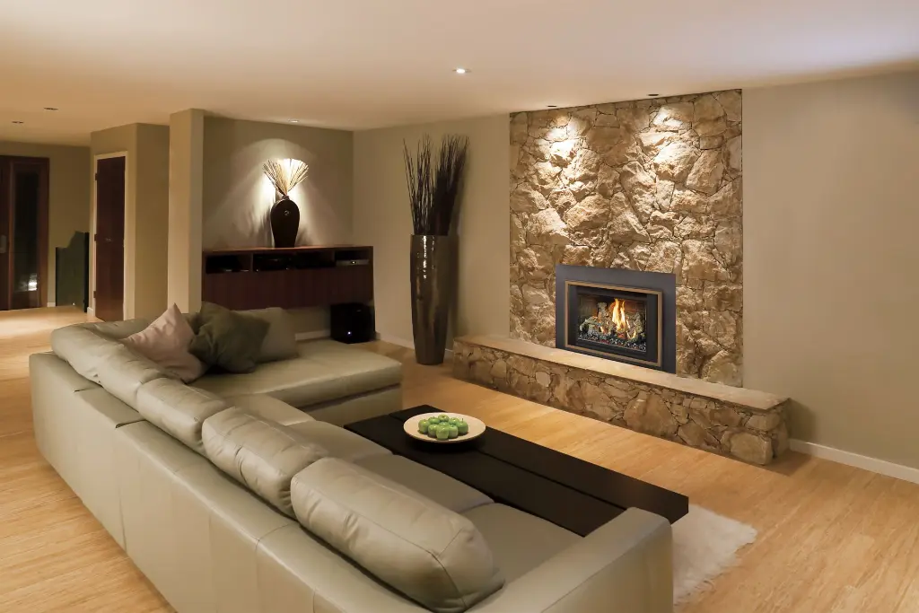 Idée de design pour un sous-sol aménagé : un mur d'accent en pierre avec l'insert au gaz 34 DVL de FireplaceXtrordinair comme point focal.