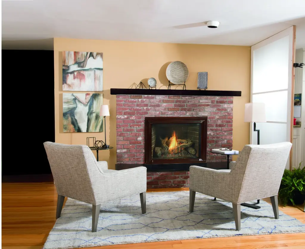 Insert au gaz Jotul GI 635 installé dans un foyer en brique rouge, créant un espace de conversation chaleureux dans un salon de style transitionnel.