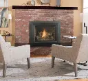 Vue rapprochée de l'insert au gaz Jotul GI 635, montrant comment il s'intègre parfaitement dans une ouverture de foyer en brique existante.