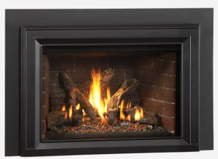 Gros plan sur l'insert au gaz Jotul GI 635, détaillant sa façade en fonte noire et l'intérieur en panneaux de briques traditionnelles.