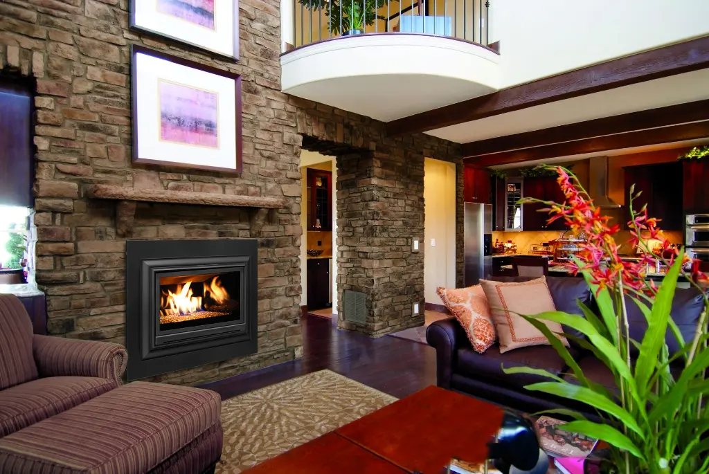 Petit insert au gaz Enviro E20, ajoutant une touche de chaleur discrète et efficace à un majestueux mur de pierres dans une maison de prestige au style chalet.